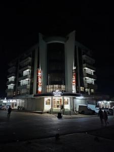un edificio de noche con gente caminando delante de él en Golden Palace Hotel, en Eldoret