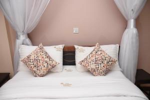 una cama con dos almohadas encima en Golden Palace Hotel, en Eldoret 5 fotos más