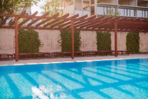 a swimming pool with benches next to a building at Admiral Luxury III Apartman By BLTN in Siófok