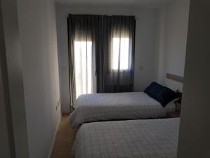 Habitación de hotel con 2 camas y ventana en Corvera Golf Holiday Home, en Murcia