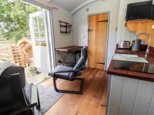 uma cozinha com duas cadeiras numa casa minúscula em The Moorhen Retreat em Oswestry