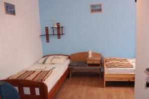a bedroom with two beds and a table with a cross on the wall at Dom Wczasowy Pod Weską in Korbielów