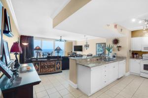 a large kitchen with white cabinets and a view of the ocean at Emerald Beach 1627 in Panama City Beach