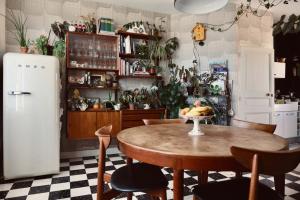 Chez Ric et Fer في Coucy-le-Château-Auffrique: مطبخ مع طاولة وكراسي وثلاجة
