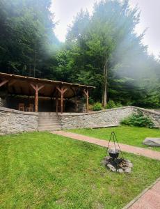 a garden with a pavilion and a stone wall at Vila Luca's in Cîrţişoara +19 photos