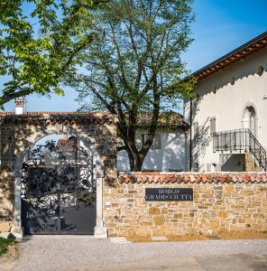 un muro di mattoni con cancello di fronte a un edificio di Borgo Gradis'ciutta a Gorizia