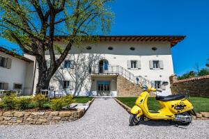 una moto amarilla estacionada frente a una casa en Borgo Gradis'ciutta, en Gorizia