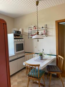 a kitchen with a table with chairs and a stove at Ferienwohnung Eva in Mureck