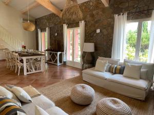 a living room with a white couch and a stone wall at Fantastic pool villa 900m to the beach; with extravagant big garden in Sainte-Maxime