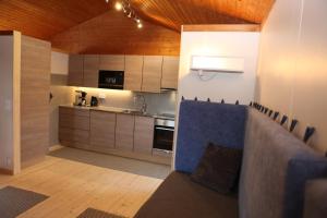 a kitchen with a blue couch in a room at Isakssons Cottage 6 in Föglö +11 photos