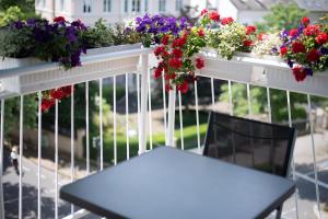 a table and chairs in front of flowers on a fence at Hotel Kurfürstenhof in Bonn
