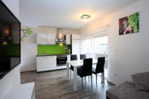 a kitchen and dining room with a table and chairs at Apartments Klemenčič in Bohinj