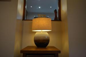 eine Lampe auf einem Tisch in einem Zimmer in der Unterkunft Luxurious Self Catering Holiday Cottage Cornwall in Menheniot