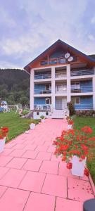 a building with flowers in front of it at Pensiunea Aurelia in Bicaz Chei