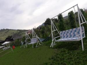 um grupo de baloiços sentados num campo de relva em Pensiunea Aurelia em Bicaz-Chei