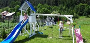 two women standing in a playground with a slide at Pensiunea Aurelia in Bicaz Chei