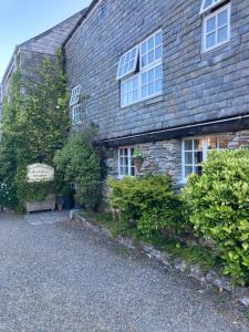 a brick house with windows and plants in front of it at Bissick Old Mill Suite in Truro +12 photos