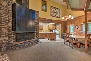 a kitchen and dining room with a stone fireplace at Rogers Cabin with Direct Access to Beaver Lake! in Garfield