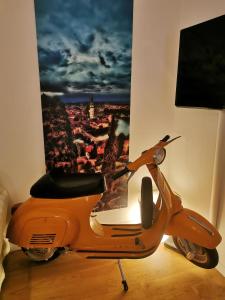 una moto naranja estacionada en una habitación con una foto en B&B Fralillo, en Verona