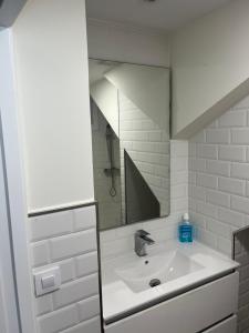La salle de bains blanche est pourvue d'un lavabo et d'un miroir. dans l'établissement A de Maria - Tres Marias Apartments, à Redondela