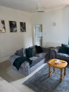a living room with a couch and a coffee table at Selston House, 3 bedroom cosy cottage Home for up to 6 Guests, Cul-de-sac on Private road in Nottingham