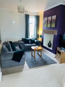 uma sala de estar com um sofá e uma mesa em Selston House, 3 bedroom cosy cottage Home for up to 6 Guests, Cul-de-sac on Private road em Nottingham