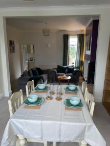 a dining room table with a white table cloth on it at Selston House, 3 bedroom cosy cottage Home for up to 6 Guests, Cul-de-sac on Private road in Nottingham