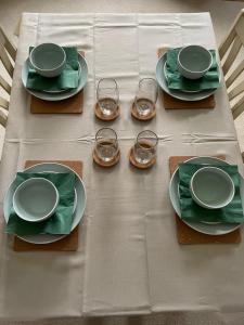 a table with plates and glasses on a white table cloth at Selston House, 3 bedroom cosy cottage Home for up to 6 Guests, Cul-de-sac on Private road in Nottingham