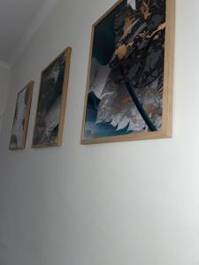 three paintings hanging on a wall in a room at Selston House, 3 bedroom cosy cottage Home for up to 6 Guests, Cul-de-sac on Private road in Nottingham