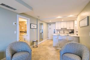 a living room with two chairs and a kitchen at Oceanfront Luxury Renovated Resort Getaway! in Fort Lauderdale
