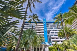 a tall building with palm trees in front of it at Oceanfront Luxury Renovated Resort Getaway! in Fort Lauderdale