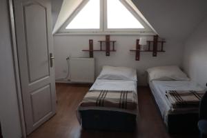 2 Betten in einem kleinen Zimmer mit Fenster in der Unterkunft Dom Wczasowy Pod Weską in Korbielów