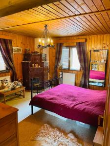 a bedroom with a bed with a purple bedspread at Casa Renilor in Azuga