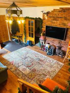 a living room with a large rug in front of a fireplace at Casa Renilor in Azuga