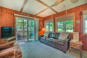 a living room with a couch and a television at Waterfront Tawas Lake Retreat with Fire Pit! in East Tawas
