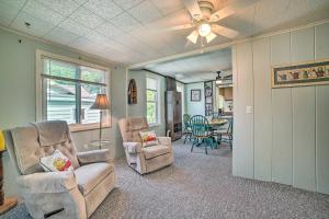 a living room with two chairs and a ceiling fan at Waterfront Tawas Lake Retreat with Fire Pit! in East Tawas