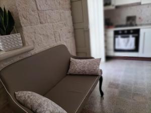 un sofá con una almohada en la sala de estar en Casetta Angelini, en Locorotondo