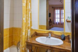 La salle de bains est pourvue d'un lavabo et d'un miroir. dans l'établissement El Rincón de Andrea Habitaciones, à Biescas