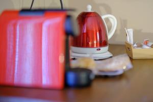 a red tea kettle sitting on top of a table at El Rincón de Andrea Habitaciones in Biescas