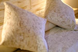 a pile of pillows sitting on top of a bed at El Rincón de Andrea Habitaciones in Biescas +8 photos