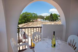 a table with glasses and a bottle of wine on a balcony at Apartamentos La Baranda in Torremolinos