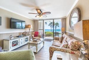 - un salon avec un canapé et un ventilateur de plafond dans l'établissement Pelican Walk 109, à Panama City Beach