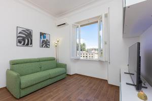 un salon avec un canapé vert et une télévision dans l'établissement Flaminia View by Rental in Rome, à Rome