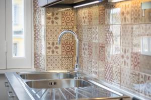 Il dispose d'une cuisine avec un évier et un mur carrelé. dans l'établissement Flaminia View by Rental in Rome, à Rome 47 autres photos