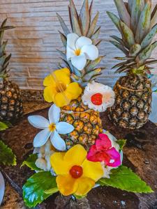 ポルト・デ・ガリーニャスにあるPousada Maraokaのテーブルの上に並ぶパイナップルと花