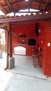 uma parede de tijolos com lareira e um banco de madeira em CASA COMPLETA-CONCEIÇÃO DE JACAREÍ -COSTA VERDE em Mangaratiba