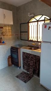 a kitchen with a stove and a sink and a refrigerator at CASA COMPLETA-CONCEIÇÃO DE JACAREÍ -COSTA VERDE in Mangaratiba