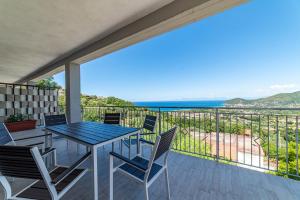 ein Tisch und Stühle auf einem Balkon mit Blick auf das Meer in der Unterkunft Casa Vacanze Il Vigneto in Castellabate