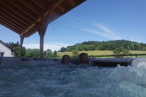 a man and a woman in a jacuzzi tub at Alb Chalet in Meßstetten