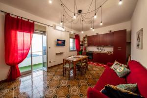 sala de estar con sofá rojo y mesa en La Valle di Hermes en Piraino